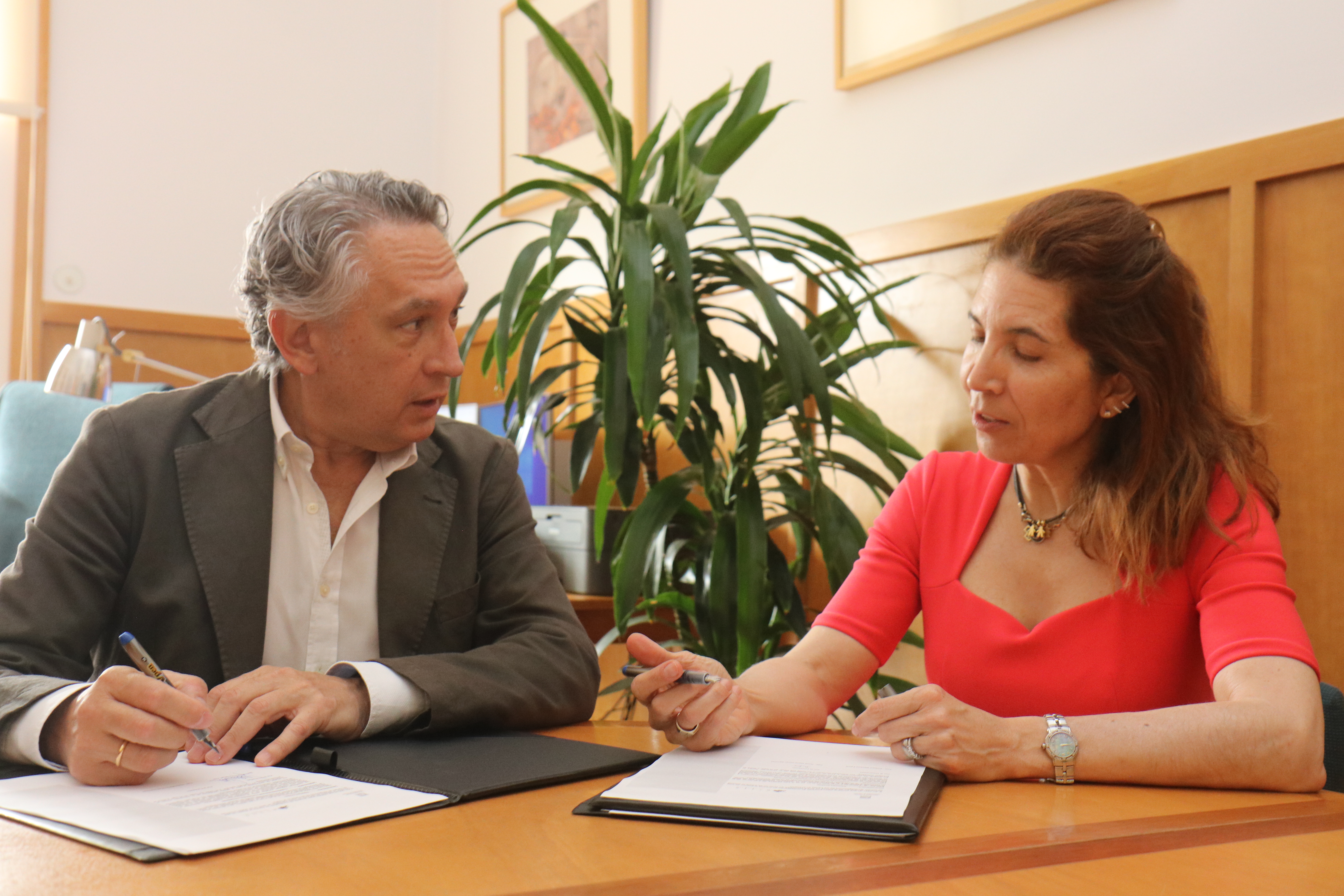 Juan Mora, vicerrector de Investigación de la Universidad de Alicante y Nuria Oliver, directora de ELLIS Alicante, firman el convenio de colaboración entre ambas entidades